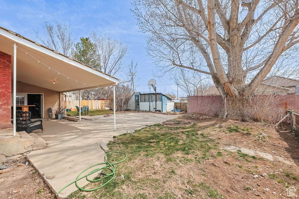 View of yard with a fenced backyard, an outdoor structure, and a patio area