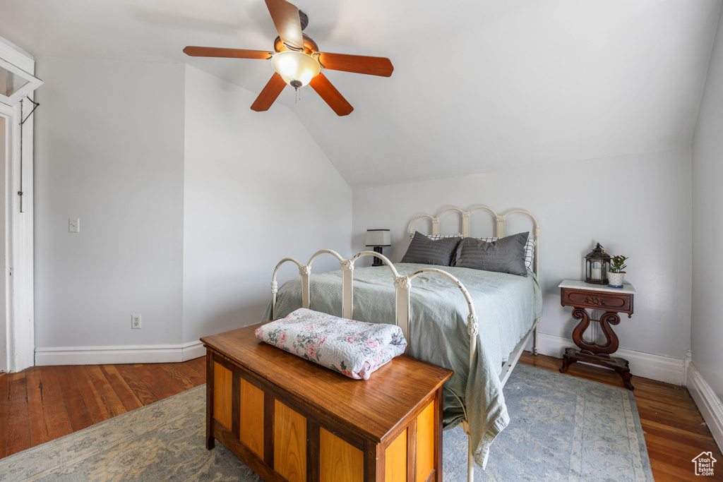 Bedroom featuring baseboards, lofted ceiling, ceiling fan, and wood-type flooring