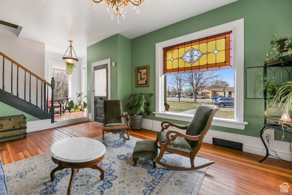Sitting room featuring visible vents, hardwood / wood-style flooring, stairway, and a healthy amount of sunlight