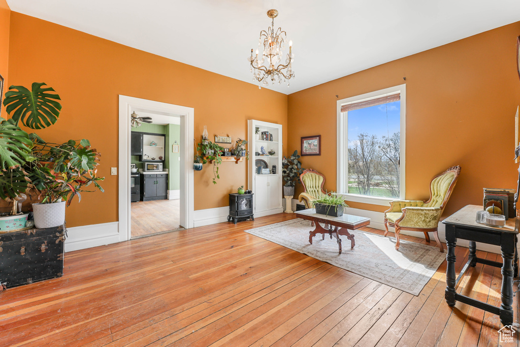 Living area featuring baseboards, a chandelier, and wood-type flooring
