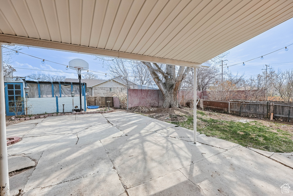 View of patio with a trampoline and a fenced backyard