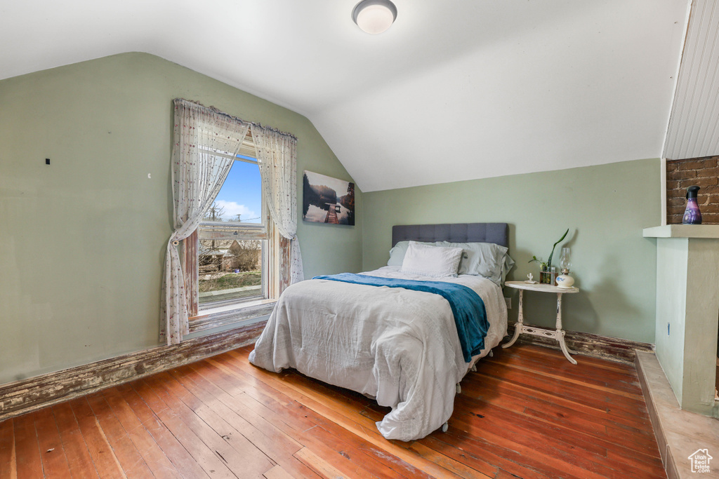 Bedroom featuring lofted ceiling and wood-type flooring