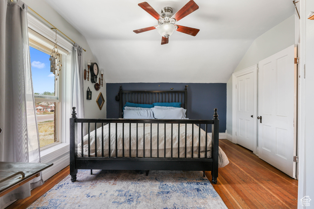 Bedroom with baseboards, lofted ceiling, a ceiling fan, and hardwood / wood-style flooring