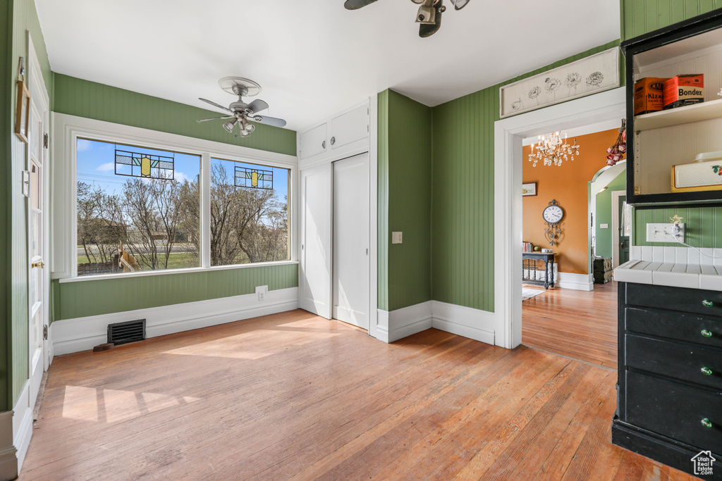 Unfurnished bedroom with a closet, light wood-type flooring, baseboards, visible vents, and arched walkways