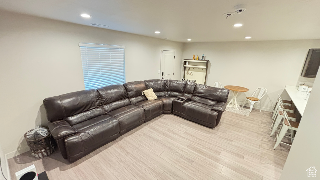 Living area featuring baseboards, light wood-type flooring, visible vents, and recessed lighting