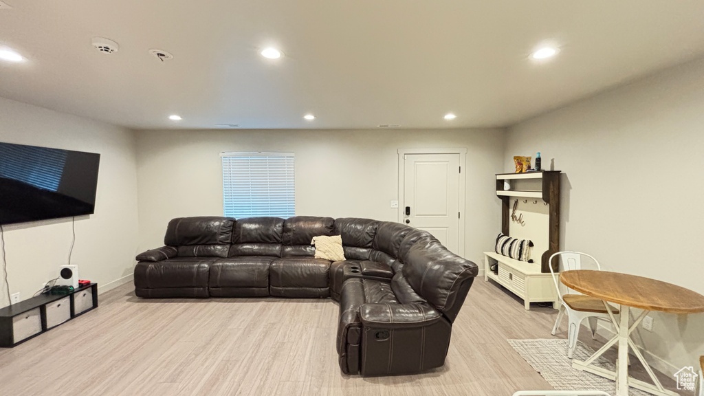Living room featuring baseboards, recessed lighting, and light wood finished floors