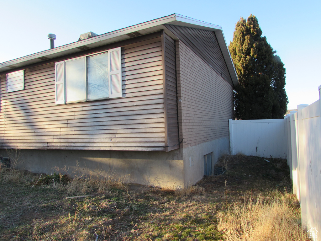 View of side of property featuring fence