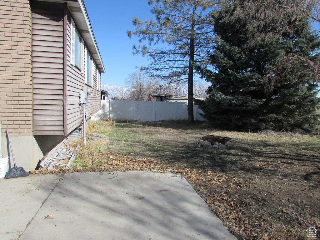 View of yard featuring fence and a patio area