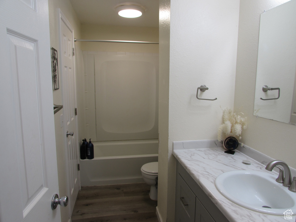 Full bath with vanity, shower / bathing tub combination, toilet, and wood finished floors