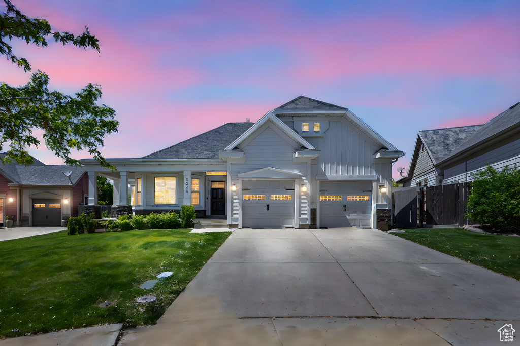 Modern farmhouse style home with concrete driveway, board and batten siding, an attached garage, and a shingled roof