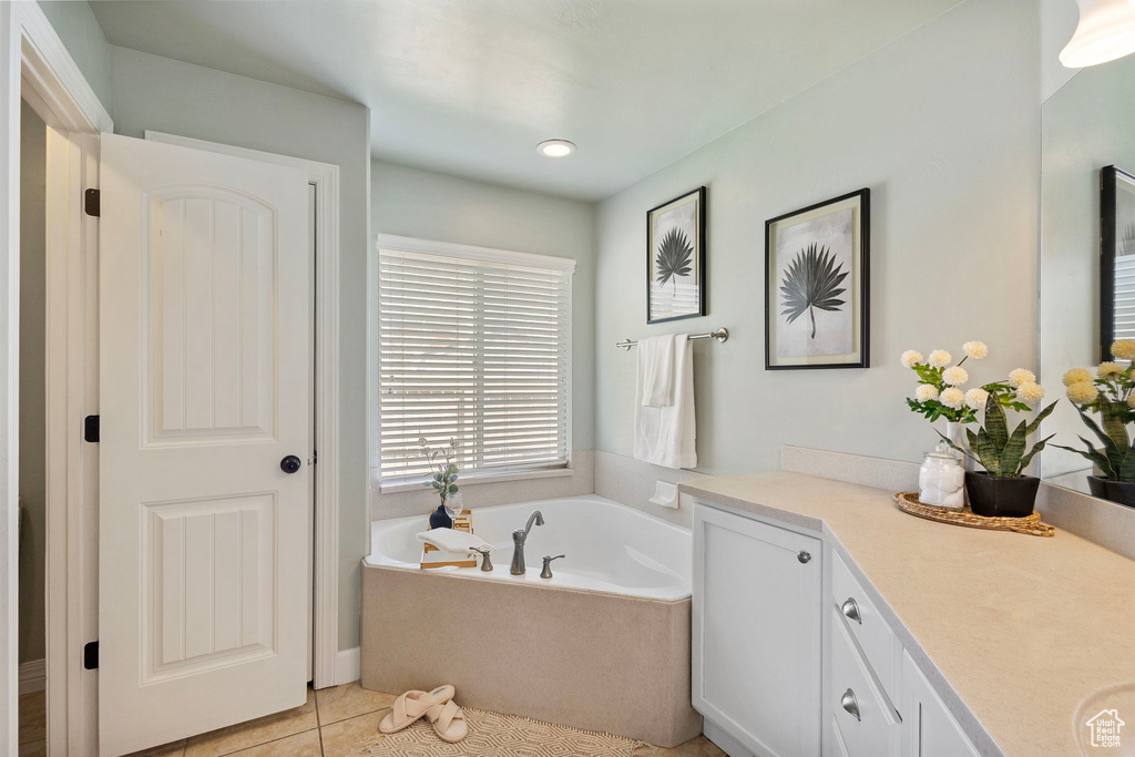 Full bathroom featuring vanity, a bath, and tile patterned flooring