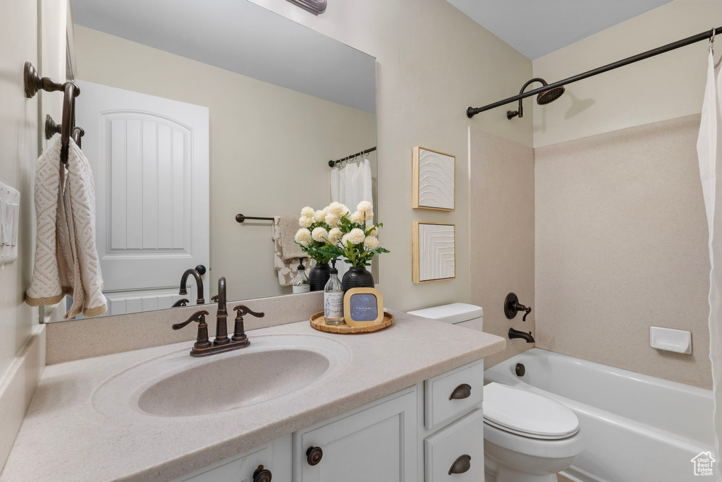 Full bathroom featuring toilet, vanity, and shower / bath combo