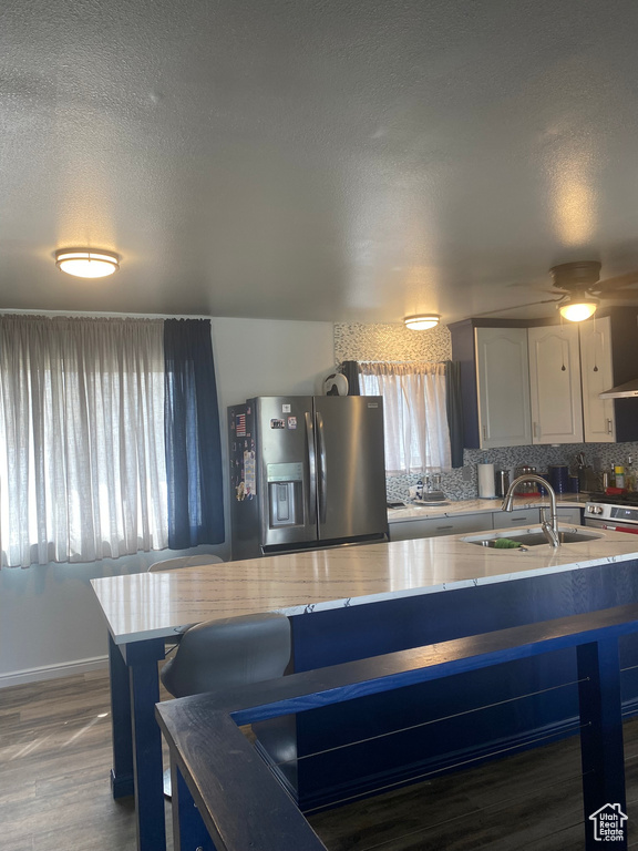 Kitchen featuring stainless steel fridge, tasteful backsplash, a textured ceiling, dark wood finished floors, and a sink