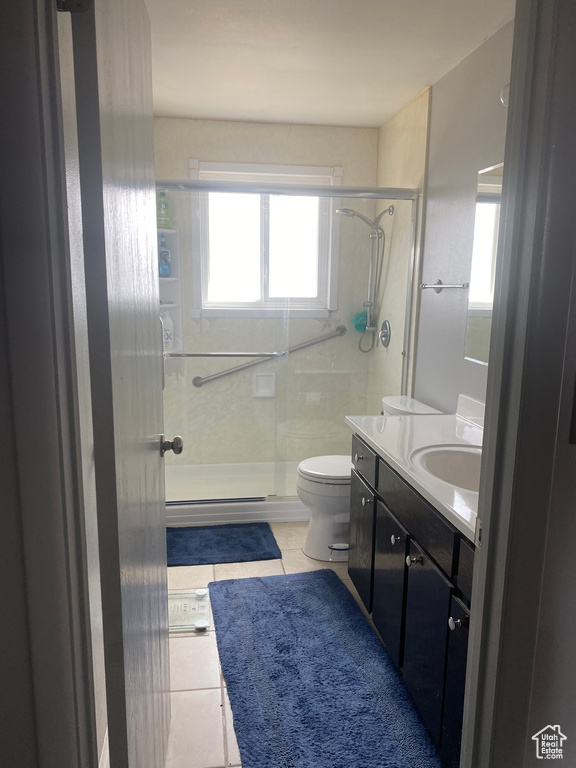 Full bathroom featuring vanity, toilet, tile patterned floors, and a shower stall