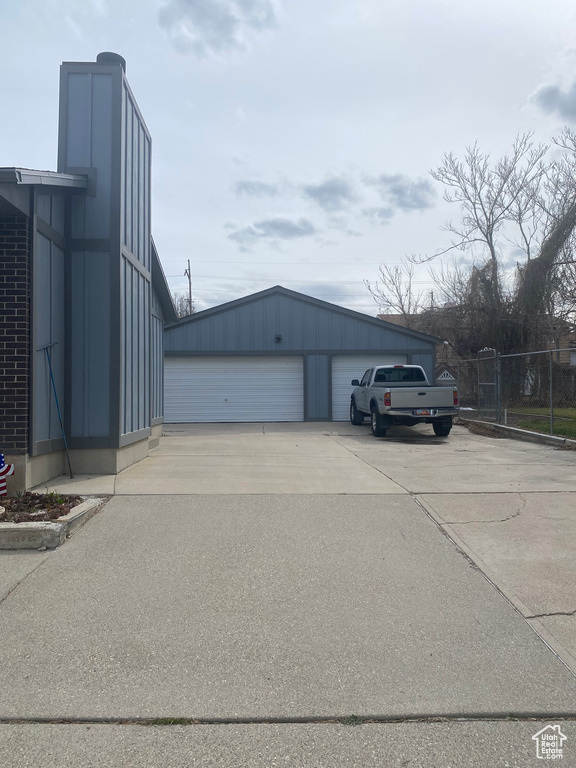 Exterior space featuring a garage, an outdoor structure, and fence