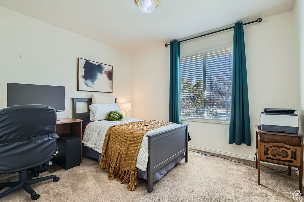 Bedroom with light carpet and baseboards