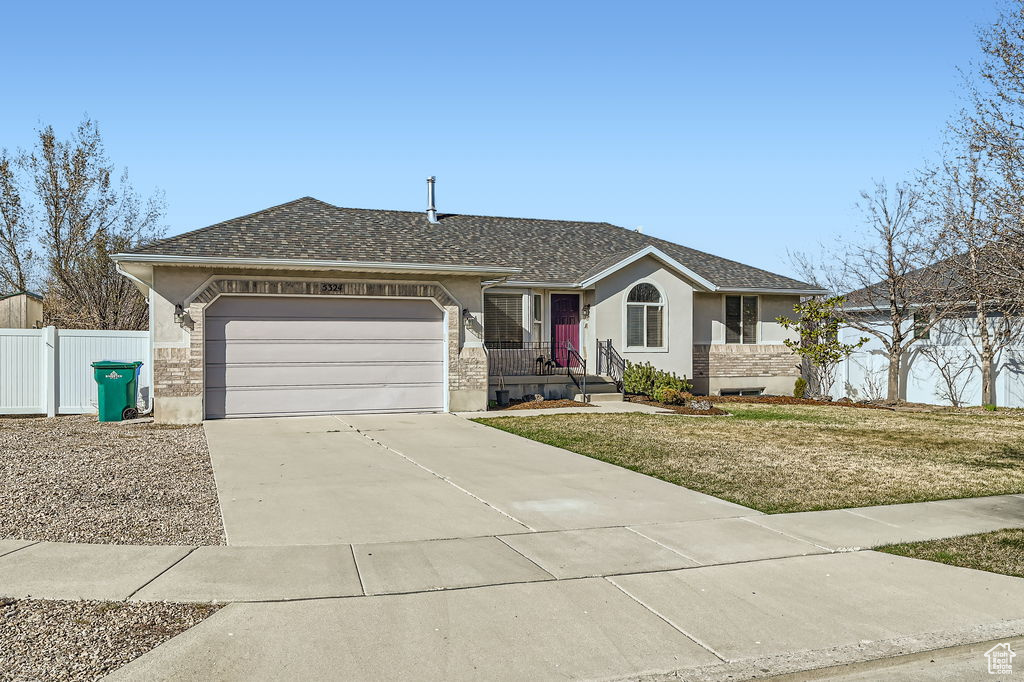 Ranch-style home featuring fence, a garage, stucco siding, driveway, and a shingled roof