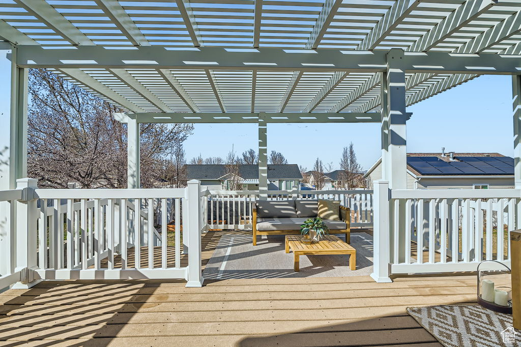 Wooden terrace with an outdoor hangout area and a pergola