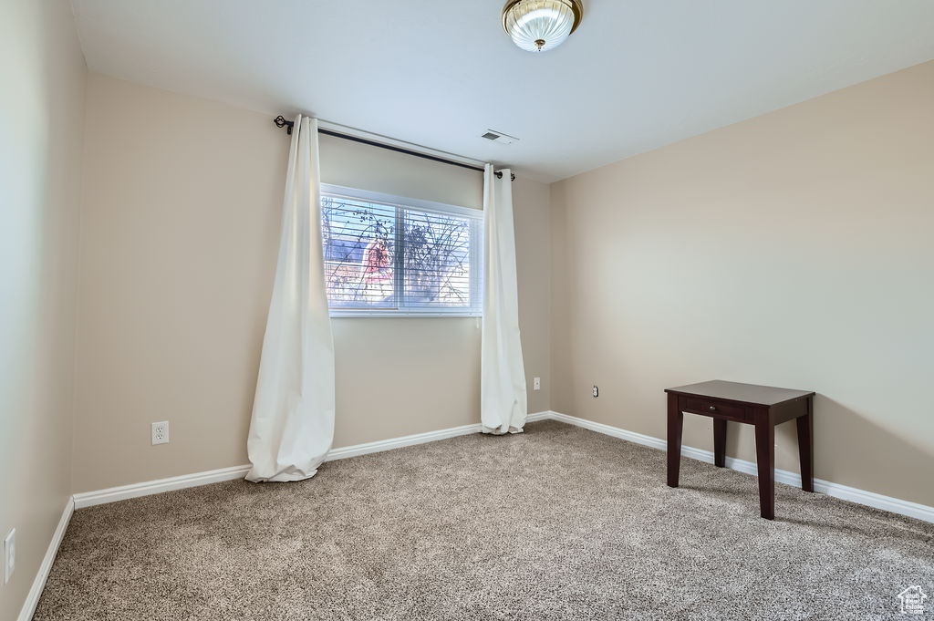Carpeted empty room with baseboards and visible vents