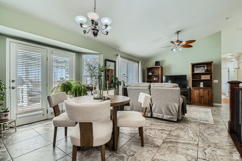 Dining room featuring vaulted ceiling and ceiling fan with notable chandelier
