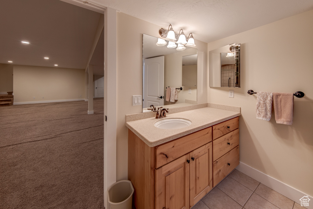 Bathroom featuring baseboards, tile patterned floors, and vanity