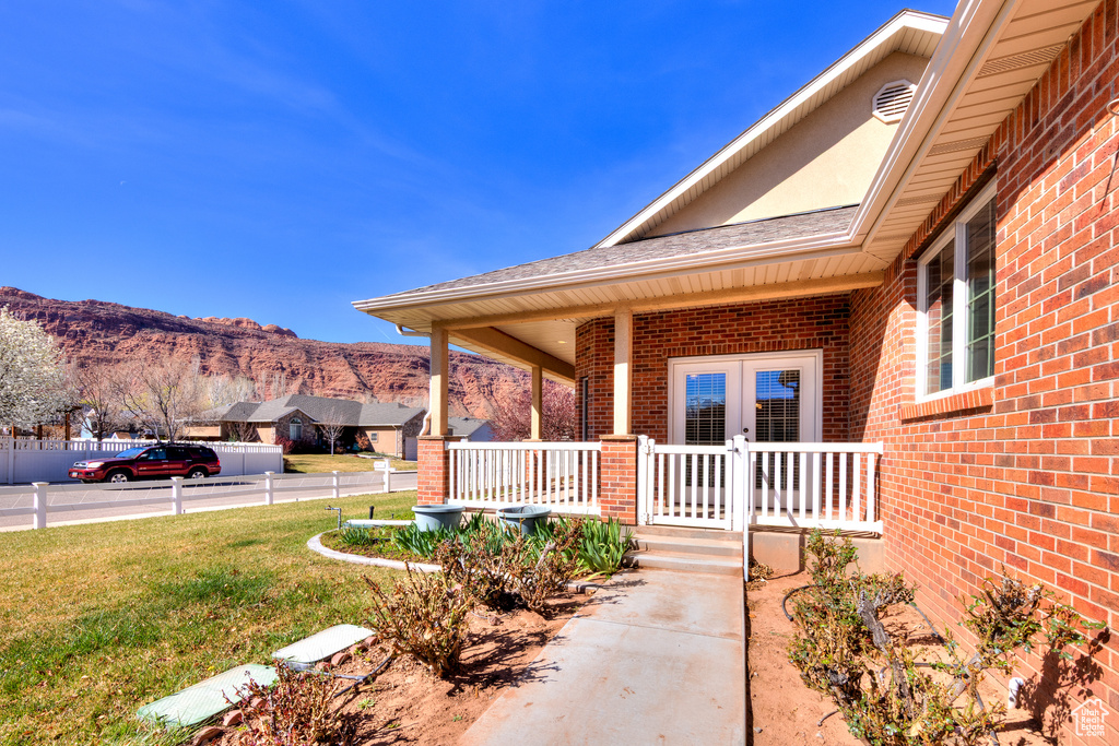 View of patio with french doors, a porch, and a mountain view