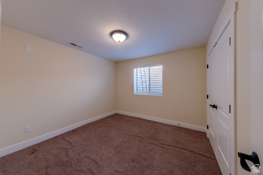 Unfurnished room featuring baseboards, visible vents, and carpet floors
