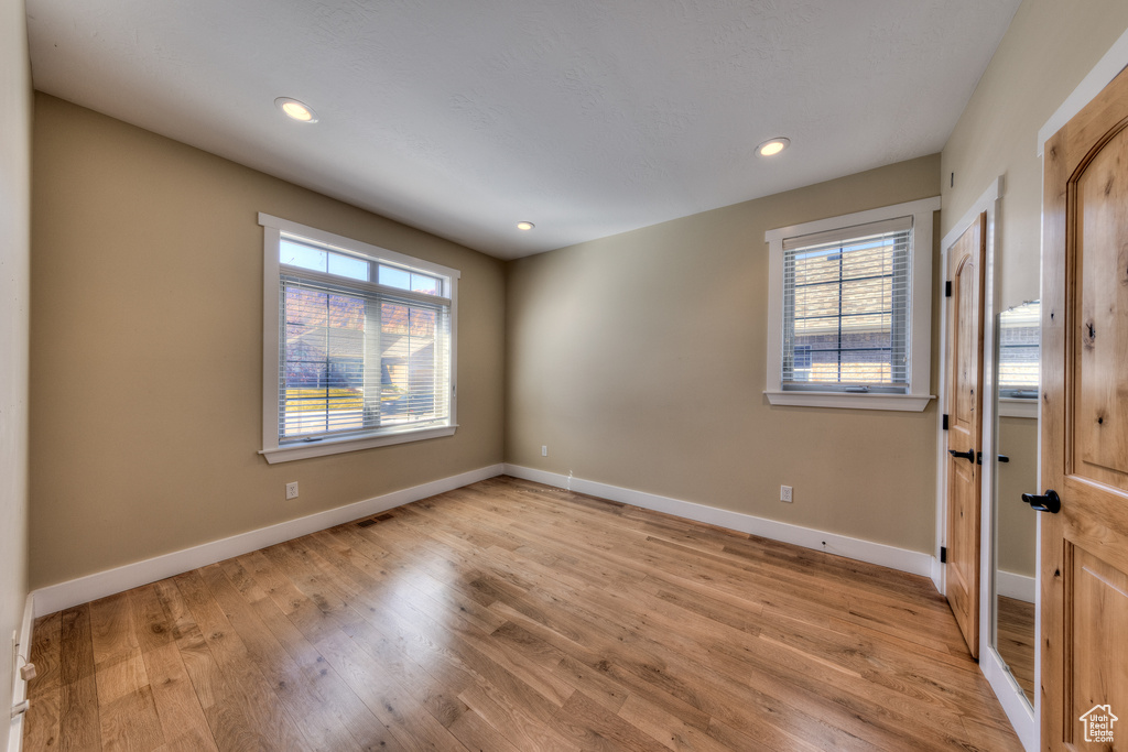 Unfurnished room featuring light wood finished floors, baseboards, and recessed lighting