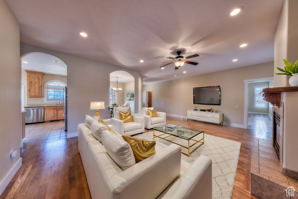 Living room with light wood-style flooring, arched walkways, and recessed lighting