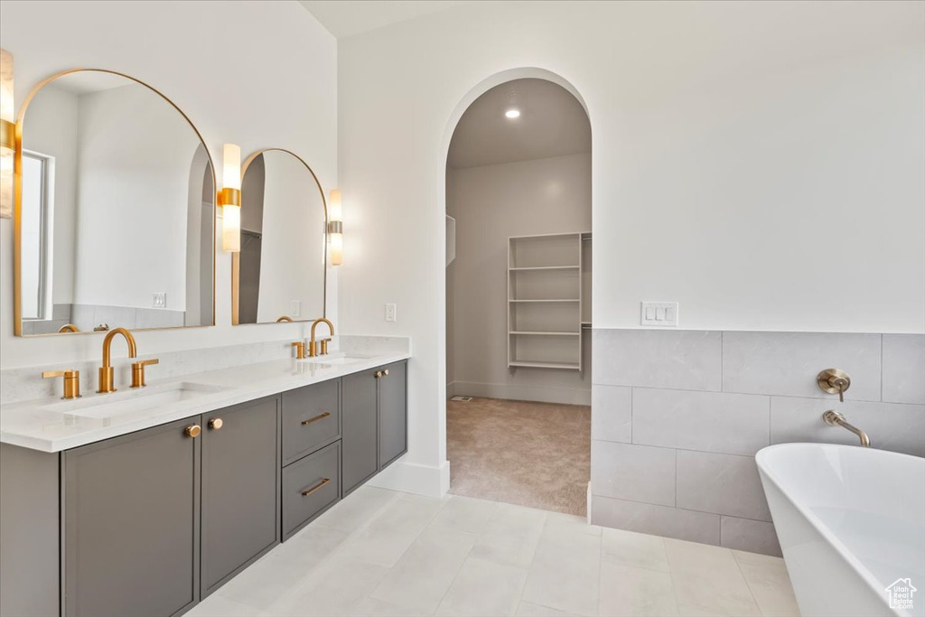 Full bathroom with a freestanding tub, double vanity, and tile patterned floors