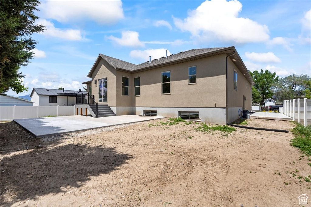 Rear view of house with a patio and stucco siding