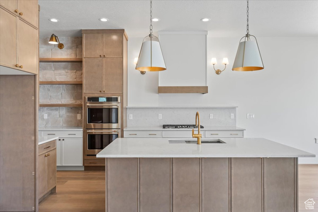 Kitchen with double oven, a sink, open shelves, tasteful backsplash, and light countertops