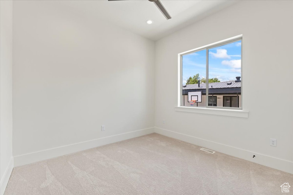 Carpeted spare room featuring baseboards, ceiling fan, and recessed lighting