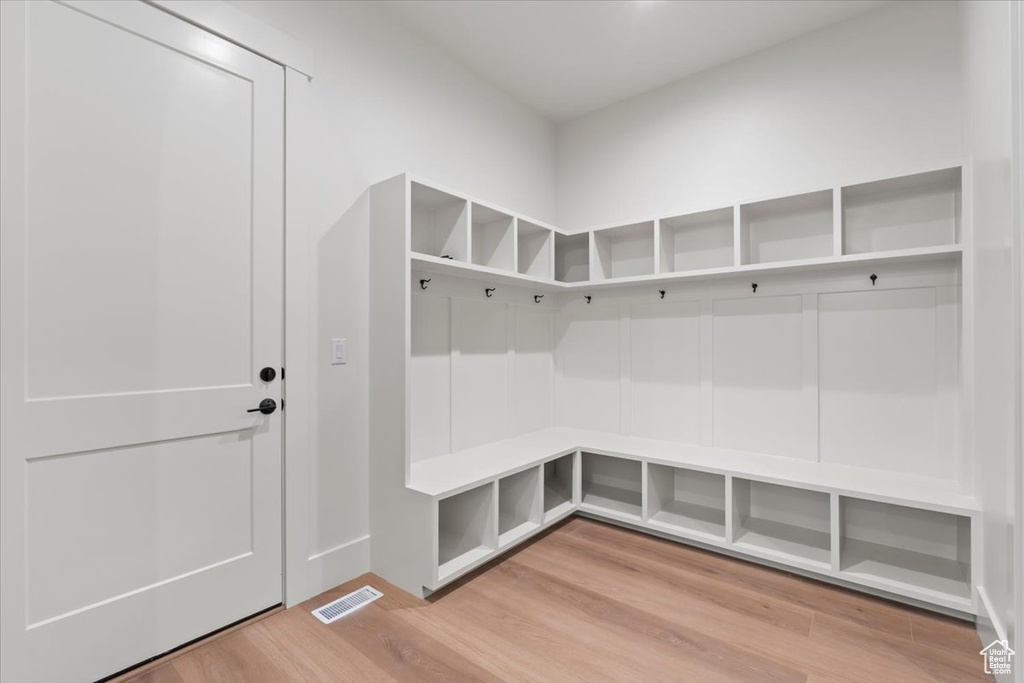 Mudroom with light wood finished floors and baseboards