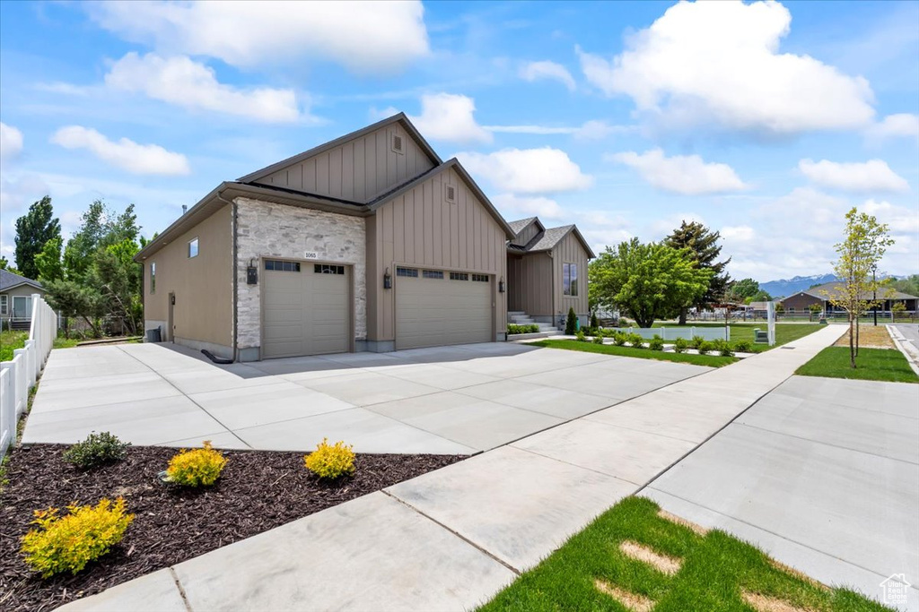 View of front of house featuring board and batten siding, a garage, and concrete driveway