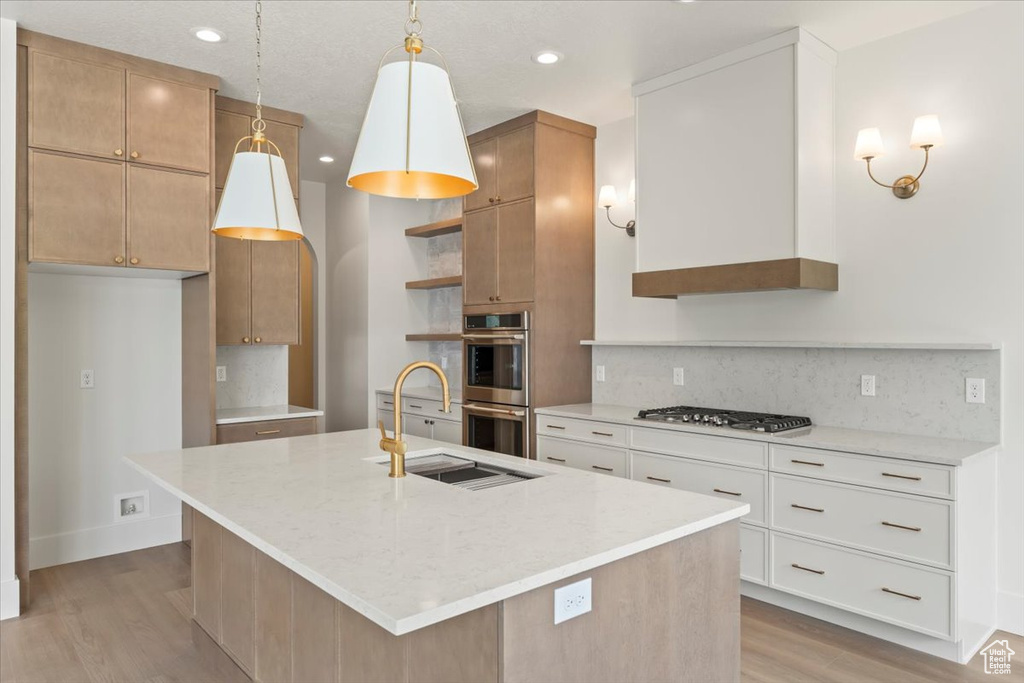 Kitchen with stainless steel appliances, open shelves, a sink, light wood finished floors, and decorative backsplash