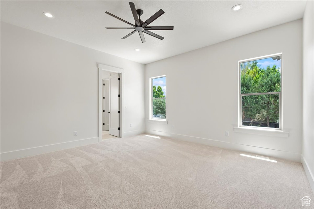 Carpeted empty room with a ceiling fan, baseboards, and recessed lighting