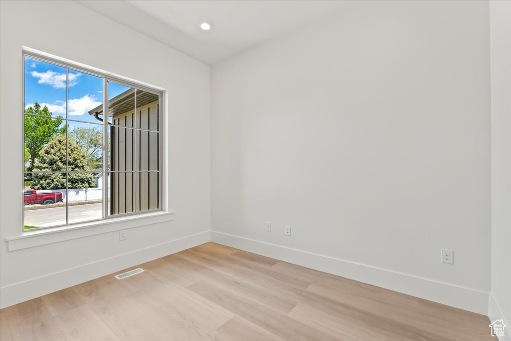 Spare room with baseboards, light wood-style flooring, and recessed lighting