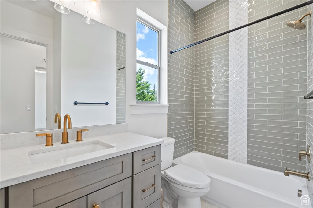 Full bath featuring toilet, vanity, and  shower combination