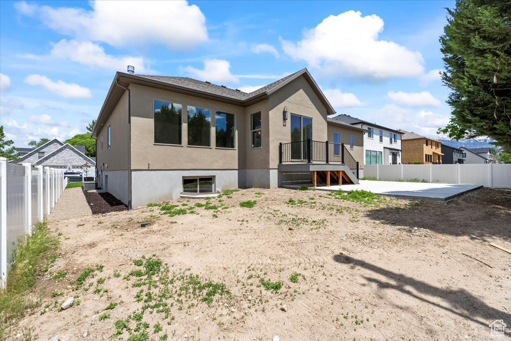 Rear view of property with a fenced backyard, stucco siding, and a patio area