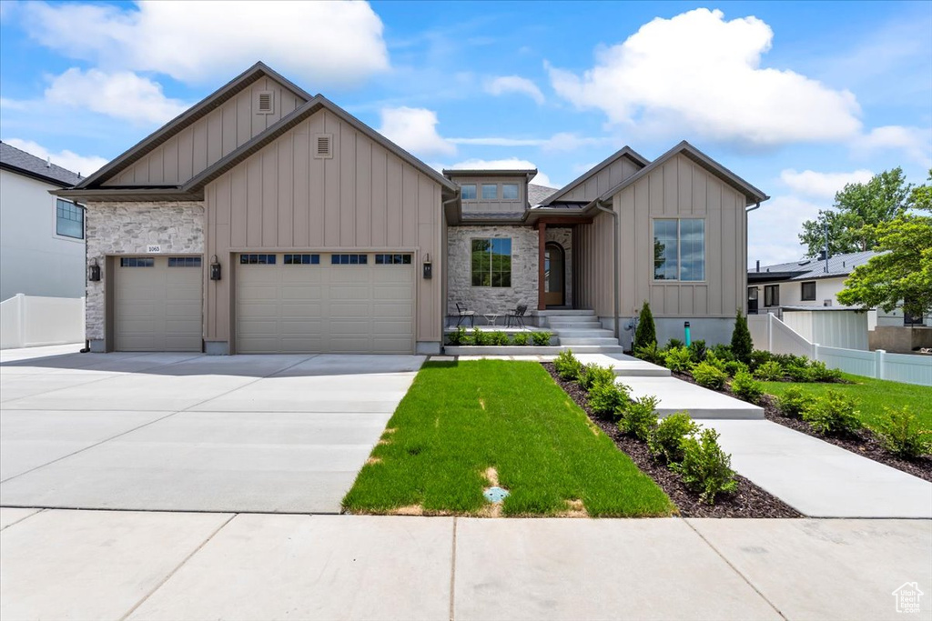View of front facade featuring board and batten siding, concrete driveway, and a garage