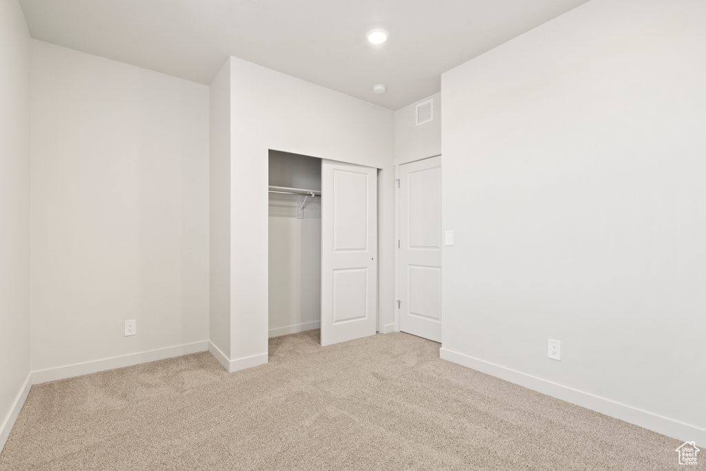 Unfurnished bedroom featuring carpet, baseboards, a closet, and recessed lighting