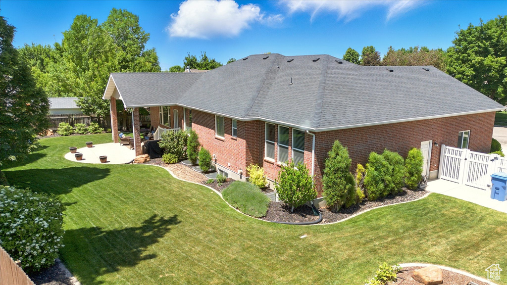 Back of house with brick siding, a patio, and a shingled roof