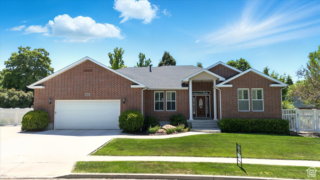View of front of home with brick siding, a garage, and concrete driveway