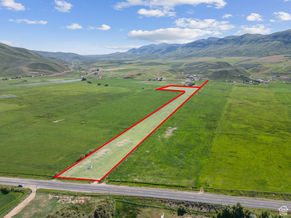 Overview of rural landscape with property parcel outlined, a mountain backdrop, and agricultural land