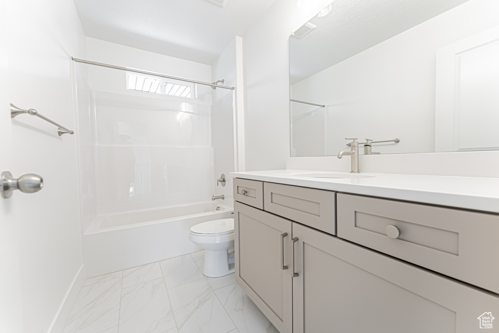 Bathroom featuring vanity, washtub / shower combination, and marble finish floors