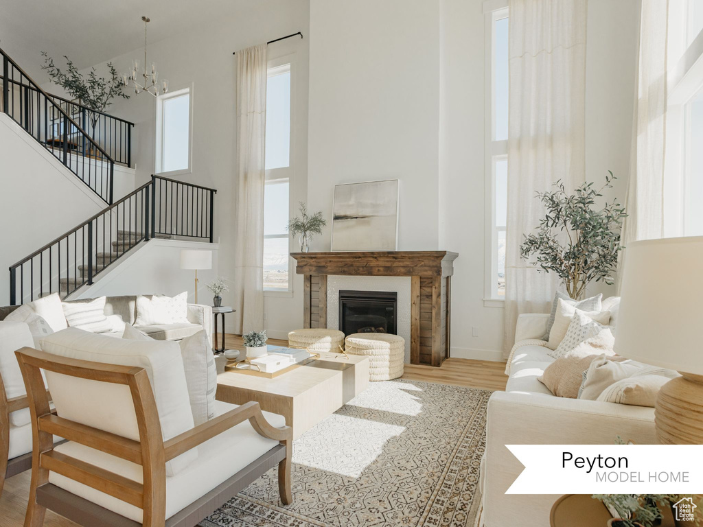 Living room with a high ceiling, a chandelier, stairway, and wood finished floors