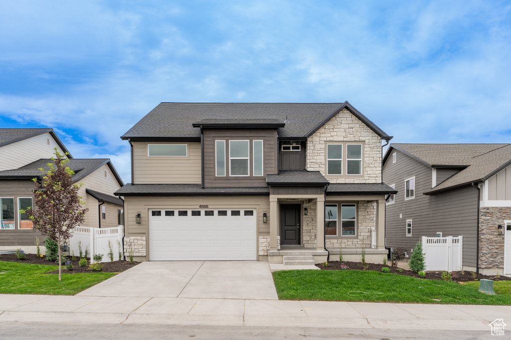 View of front of house featuring stone siding, concrete driveway, a garage, and roof with shingles