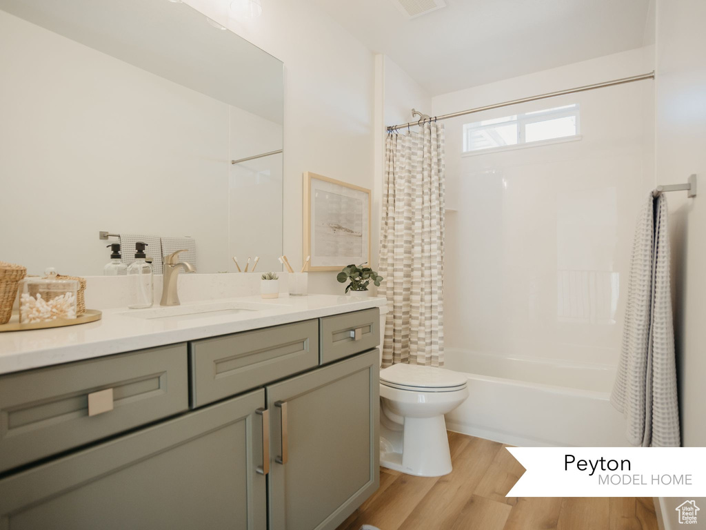 Full bath featuring shower / bathtub combination with curtain, toilet, vanity, and wood finished floors