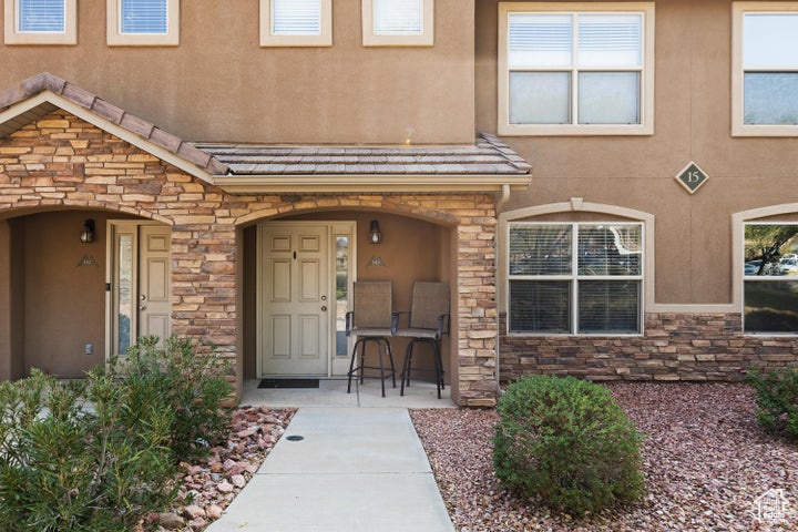 View of exterior entry with stone siding and stucco siding